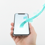 Hand holding smartphone with a glowing digital roadmap path emerging toward business success.