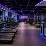 A modern Anytime Fitness gym interior in 2026 with purple ambient lighting and high-tech fitness equipment.