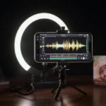 A smartphone mounted on a tripod recording a product review with a small LED ring light in a professional home office setting.