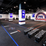 Modern F45 Training studio interior featuring blue, red, and white equipment, digital screens showing workouts, and a clean, high-energy functional training floor.