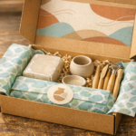 Open hobby subscription box on a wooden table featuring a curated pottery starter kit with tools and patterned tissue paper.