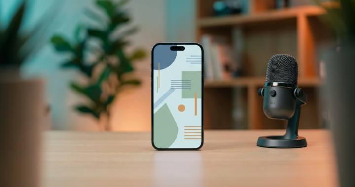 Centered smartphone with creator setup and microphone on a desk in a modern home office (2026)