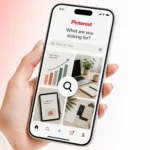 A smartphone showing the Pinterest search interface with a magnifying glass over business pins, illustrating market research.
